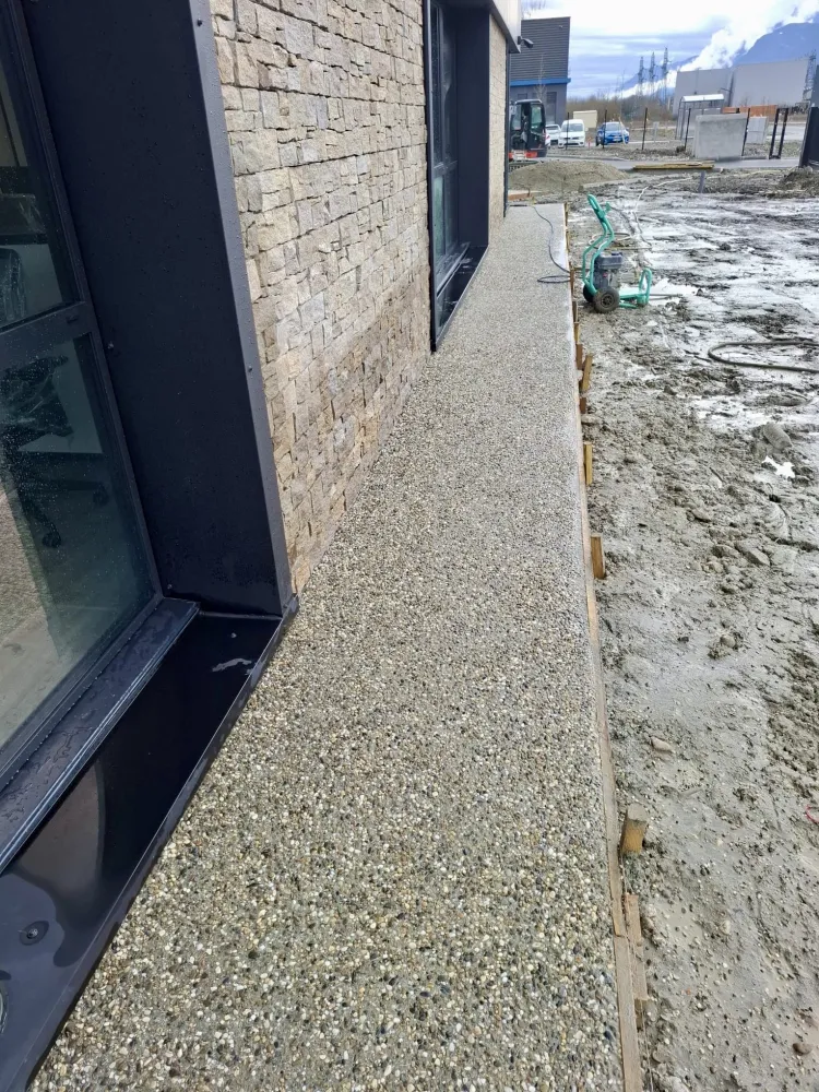 Création trottoir en béton désactivé autour d'un batiment